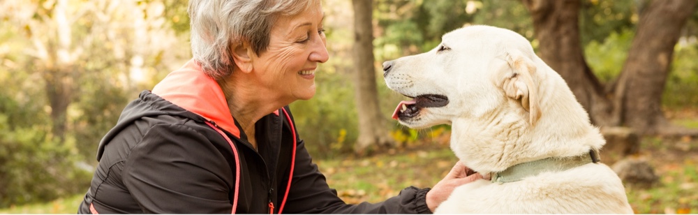 Lady smiling and petting her dog